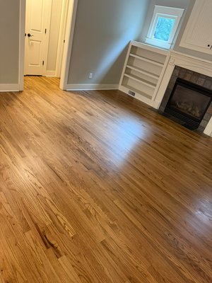 Project #208 - This hardwood flooring project highlights the natural character and warmth of the wood throughout multiple areas of the home, including living spaces, hallways, kitchen, and staircase. Rich wood tones, visible grain, decorative border details, and a polished finish create a cohesive, timeless look while preserving the character of the home.