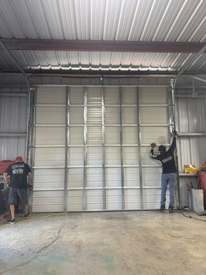 Commercial sectional door replacement - Replaced this old commercial sectional door with a brand-new one in Key West. Installed the new door with all new hardware — springs, cables, rollers, and tracks — safe operation. Another business with a door built to last.