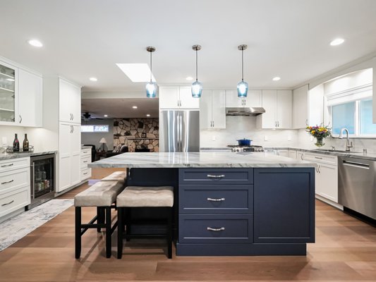 TIdal Vein Axis - This kitchen remodel was designed to reflect a calm coastal-modern atmosphere with a bright, open layout. White cabinetry, soft marble surfaces, and warm wood flooring established a clean and inviting foundation, while the navy island introduced depth and visual contrast. Blue glass pendants and natural light further emphasized the cool, uplifting palette. TIdal Vein Axis - This kitchen remodel was designed to reflect a calm coastal-modern atmosphere with a bright, open layout. White cabinetry, soft marble surfaces, and warm wood flooring established a clean and inviting foundation, while the navy island introduced depth and visual contrast. Blue glass pendants and natural light further emphasized the cool, uplifting palette.