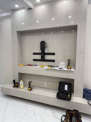 89” TV Mounting on Tile – Secure & Precision Installation - This project involved mounting a 75-inch television directly onto a tiled wall, requiring careful planning and precision drilling to avoid cracking or damaging the tile.
The installation began with accurately locating wall studs behind the tile to ensure a structurally secure mount. Specialized masonry drill bits were used to penetrate the tile cleanly, followed by heavy-duty anchors and lag bolts to safely support the weight of the TV.
The mount was leveled precisely for a clean, professional look, and all wiring was neatly managed for a streamlined finish. The result is a secure, sturdy installation that enhances the space while protecting both the tile and the television.
Services provided:
• Stud locating behind tile
• Precision tile drilling
• Heavy-duty mounting hardware installation
• Level alignment
• Clean wire management 89” TV Mounting on Tile – Secure & Precision Installation - This project involved mounting a 75-inch television directly onto a tiled wall, requiring careful planning and precision drilling to avoid cracking or damaging the tile.
The installation began with accurately locating wall studs behind the tile to ensure a structurally secure mount. Specialized masonry drill bits were used to penetrate the tile cleanly, followed by heavy-duty anchors and lag bolts to safely support the weight of the TV.
The mount was leveled precisely for a clean, professional look, and all wiring was neatly managed for a streamlined finish. The result is a secure, sturdy installation that enhances the space while protecting both the tile and the television.
Services provided:
• Stud locating behind tile
• Precision tile drilling
• Heavy-duty mounting hardware installation
• Level alignment
• Clean wire management