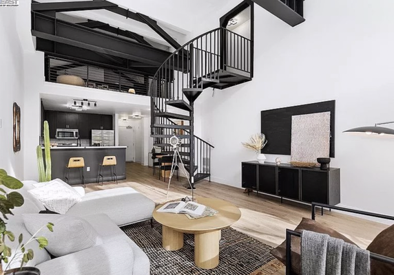 Stylish Loft in the Heart of Oakland - Home staging for a loft in the heart of Oakland. We used a lot of natural wood and black metal furniture to accent and complement the loft's architectural details — metal beams and a spiral staircase.