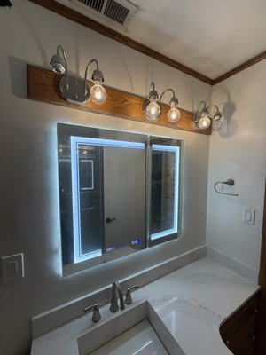 Bathroom Mirror Installation, LED – Lakewood, CA - This custom LED bathroom mirror installation in Lakewood, CA was done in just a few hours. More than just putting a new mirror in place was needed. We cut into the drywall, did work on the concrete behind the wall, prepped and ran the electrical connection, and got everything ready for the new lighted mirror.
If you’re working with concrete, you’ll need the right tools and experience especially if it involves electrical work and delicate mounting. Once all the parts were installed and wired, we patched and finished the wall, installed the mirror and tested the lights and controls. The end result is a clean, modern bathroom upgrade complete with a fully functional LED mirror and a neat finished installation. Bathroom Mirror Installation, LED – Lakewood, CA - This custom LED bathroom mirror installation in Lakewood, CA was done in just a few hours. More than just putting a new mirror in place was needed. We cut into the drywall, did work on the concrete behind the wall, prepped and ran the electrical connection, and got everything ready for the new lighted mirror.
If you’re working with concrete, you’ll need the right tools and experience especially if it involves electrical work and delicate mounting. Once all the parts were installed and wired, we patched and finished the wall, installed the mirror and tested the lights and controls. The end result is a clean, modern bathroom upgrade complete with a fully functional LED mirror and a neat finished installation.