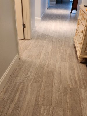 Tile Installation - This condo owner wanted to add tile to carpeted areas and have the kitchen, bedrooms, and bathrooms completely tiled. We needed to butt matching tile to the existing tile in the living room and have it blend down the hallways to the bedrooms and entryway. Lay a Diamond pattern in the kitchen and bedrooms.