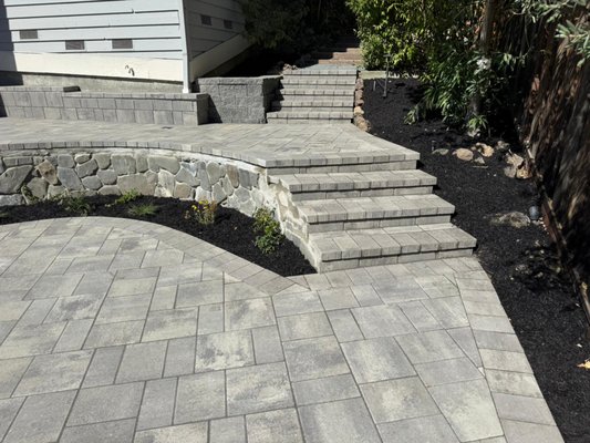 Riviera Belgard Paver backyard Transformation. - For this project, we worked closely with our client to completely transform their backyard. We replaced the old deck with a new Trex deck, installed turf and Belgard pavers, including a cozy fire pit area and added several steps for a smooth, functional layout. We also built multiple legacy block walls, installed patio lighting, and planted new greenery with drip irrigation to bring the space to life. The client was thrilled with the results, enjoying a backyard that’s both stylish and perfectly suited for relaxation and entertaining. Riviera Belgard Paver backyard Transformation. - For this project, we worked closely with our client to completely transform their backyard. We replaced the old deck with a new Trex deck, installed turf and Belgard pavers, including a cozy fire pit area and added several steps for a smooth, functional layout. We also built multiple legacy block walls, installed patio lighting, and planted new greenery with drip irrigation to bring the space to life. The client was thrilled with the results, enjoying a backyard that’s both stylish and perfectly suited for relaxation and entertaining.