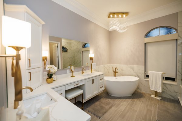 A Luxurious Bathroom Remodel With All The Finishes - This exquisite bathroom remodel by CMK Construction, Inc. defines modern luxury and elegance. Every detail from the gold fixtures to the marble-style tile was curated to create a space that feels timeless and indulgent. The freestanding tub, soft lighting, and custom vanity design combine sophistication with comfort, while the subtle lavender-gray wall tone enhances the serene atmosphere. Gold hardware, statement lighting, and layered textures add richness and dimension to the design. A perfect example of CMK Construction, Inc.’s craftsmanship and design expertise, this Tampa bathroom renovation blends functionality, style, and spa-like tranquility for the ultimate retreat. A Luxurious Bathroom Remodel With All The Finishes - This exquisite bathroom remodel by CMK Construction, Inc. defines modern luxury and elegance. Every detail from the gold fixtures to the marble-style tile was curated to create a space that feels timeless and indulgent. The freestanding tub, soft lighting, and custom vanity design combine sophistication with comfort, while the subtle lavender-gray wall tone enhances the serene atmosphere. Gold hardware, statement lighting, and layered textures add richness and dimension to the design. A perfect example of CMK Construction, Inc.’s craftsmanship and design expertise, this Tampa bathroom renovation blends functionality, style, and spa-like tranquility for the ultimate retreat.