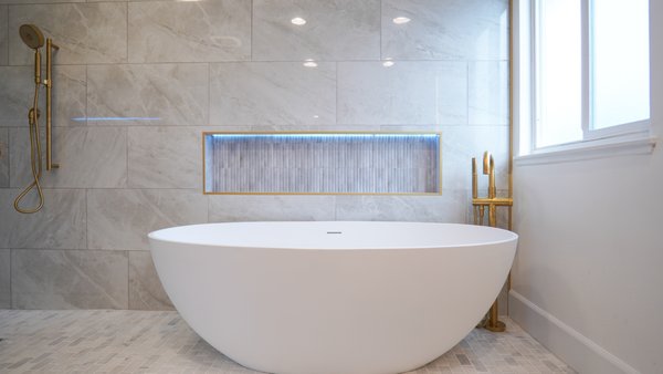 MASTER BATHROOM REMODEL 2024 - Imagine stepping into your master bathroom—a sanctuary of luxury and relaxation. A stylish soaking tub takes center stage, inviting you to unwind. A sleek double vanity with marble countertops provides practicality for couples. A niche adds a personalized touch, perfect for displaying décor or storing essentials. Transparent glass doors create an open and airy feel, while gold fixtures add a touch of opulence. The rain shower offers a spa-like experience, completing this haven of comfort and sophistication.