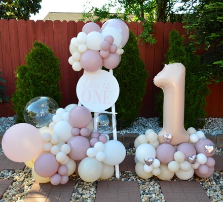 Sweet First Birthday - This gorgeous balloon setup was created to celebrate a sweet first birthday! Featuring soft blush, ivory, and mauve tones, the design includes a custom “Ella is ONE” sign, clear bubble balloons, and a large number 1 balloon surrounded by heart accents.
Perfect for backyard celebrations, this arrangement added a stylish, photo-ready touch to the day. Every detail — from the color palette to the elegant layout — was designed with love to make the moment truly unforgettable.
We specialize in custom balloon decor tailored to your event and theme! Sweet First Birthday - This gorgeous balloon setup was created to celebrate a sweet first birthday! Featuring soft blush, ivory, and mauve tones, the design includes a custom “Ella is ONE” sign, clear bubble balloons, and a large number 1 balloon surrounded by heart accents.
Perfect for backyard celebrations, this arrangement added a stylish, photo-ready touch to the day. Every detail — from the color palette to the elegant layout — was designed with love to make the moment truly unforgettable.
We specialize in custom balloon decor tailored to your event and theme!