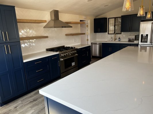 Kitchen remodel in Serra Mesa - Navy shaker cabinets, a long quartz island, floating wood shelves and a professional range.
This kitchen opens directly into the family room under a vaulted ceiling, with the long island between the two. The first photos show the kitchen before and during the work. Kitchen remodel in Serra Mesa - Navy shaker cabinets, a long quartz island, floating wood shelves and a professional range.
This kitchen opens directly into the family room under a vaulted ceiling, with the long island between the two. The first photos show the kitchen before and during the work.