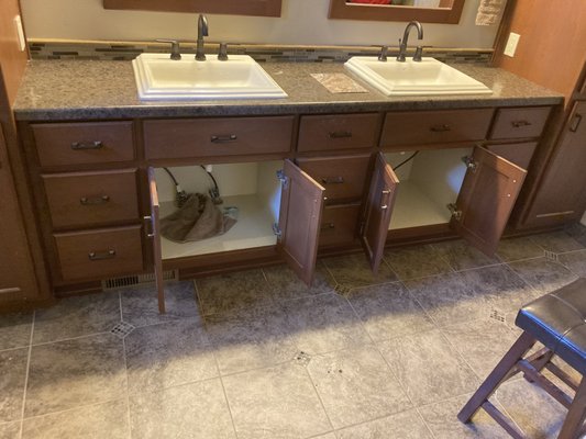 Bathroom Vanity Resurface - The only vanity had chemicals spilt on it. Put new laminate on counter tops and added a custom wood rail to tie the cabinets together.
