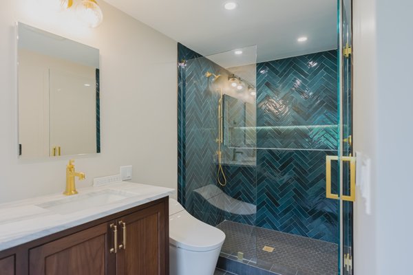 Two-Bathroom Remodel in Grafton, MA - This homeowner chose us after seeing the level of detail in our previous projects. They appreciated that we provide full plans and renderings before any work begins, which helped them feel confident about every decision from layout to finishes.

Both bathrooms were fully gutted and redesigned to fit the family’s taste and daily needs. The primary bathroom now has a larger shower with heated floors, custom niches with LED lighting, a double vanity with recessed medicine mirrors, and beautiful coastal green tile with champagne bronze fixtures. It also features one of the best toilets on the market for comfort and performance.

The kids’ bathroom received a full upgrade as well, including a better layout, a fresh tub replacement to open up the room, updated storage, and a brighter color palette.

These spaces now feel modern, comfortable, and built for the long run. A great example of how thoughtful design and detailed planning can transform two important rooms in a home.