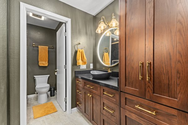 Bathroom Remodeling - San Diego - We also completed a second bathroom for our client in San Diego, transforming it from an outdated space into a stunning, spa-inspired retreat. This design features sleek black tiles paired with rich dark wood vanity tones, creating a bold yet calming atmosphere. We upgraded the layout, fixtures, and finishes to enhance both functionality and comfort, resulting in a modern bathroom that feels luxurious, relaxing, and perfectly designed for everyday use.