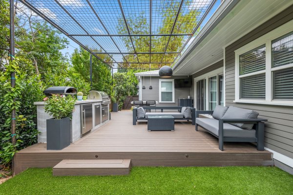 Barton Hills - We love our Zilker clients and the beautiful renovation our design + build team saw through! This backyard turned into the ultimate space for entertaining friends and family. The composite deck and pet-friendly artificial turf creates a seamless transition from the sliding doors to the pool space. The outdoor kitchen is clad in lueder stone for a modern look that ties into the poolside patio and coping, and the hog panel pergola will be covered with ‘tangerine beauty’ cross vine by the fall! The additional bells and whistle include a matching composite bench with interior storage and low voltage lighting throughout the backyard for nighttime lounging. In the front yard, we created a new fence with a custom automated car gate and new plantings with accent lighting for curb appeal. We couldn’t be more thrilled with this stunning project, and our clients are eagerly anticipating their summer cookouts!