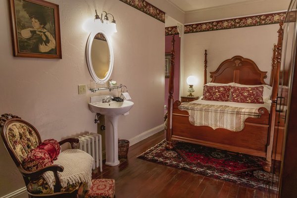 Corona de Oro - Room 4 - Enjoy easy access to all that Trinity County has to offer from this garden-inspired suite. With views of the bandstand and greens from every window, Corona de Oro features a window seat that's perfect for day dreams, a dedicated soaking tub area, and a luxurious queen-sized four poster bed.
With Main Street at your doorstep, you'll be in the heart of culture and history in downtown Weaverville, and a skip away from endless miles of trails in the Trinity Alps.
Corona de Oro is part of the Weaverville Hotel at the base of the stunning Trinity Alps. Enjoy easy access to hikes, fishing, lakes, mountains and more, making it the perfect base for all your North State adventures.
This room features:
- A poster queen-sized bed
- An in-room fireplace with a sitting area and pedastal sink
- In-room coffee station and dedicated clawfoot soaking tub area
- A window seat with views of the greens/bandstand, perfect for afternoon naps and reading
- High speed internet
- Garden-inspired period details and decor
- Access to a shared parlor space (open from 7 a.m. — 10 p.m.) Corona de Oro - Room 4 - Enjoy easy access to all that Trinity County has to offer from this garden-inspired suite. With views of the bandstand and greens from every window, Corona de Oro features a window seat that's perfect for day dreams, a dedicated soaking tub area, and a luxurious queen-sized four poster bed.
With Main Street at your doorstep, you'll be in the heart of culture and history in downtown Weaverville, and a skip away from endless miles of trails in the Trinity Alps.
Corona de Oro is part of the Weaverville Hotel at the base of the stunning Trinity Alps. Enjoy easy access to hikes, fishing, lakes, mountains and more, making it the perfect base for all your North State adventures.
This room features:
- A poster queen-sized bed
- An in-room fireplace with a sitting area and pedastal sink
- In-room coffee station and dedicated clawfoot soaking tub area
- A window seat with views of the greens/bandstand, perfect for afternoon naps and reading
- High speed internet
- Garden-inspired period details and decor
- Access to a shared parlor space (open from 7 a.m. — 10 p.m.)