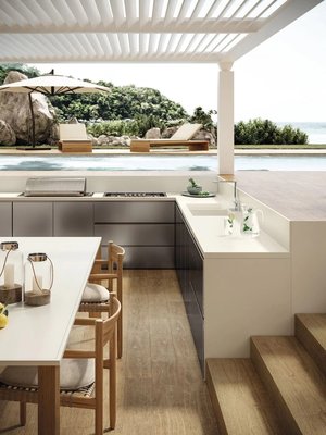 Outdoor Living Spaces - Planning your outdoor kitchen and entertaining space is an important step in the process. Be sure to think about factors such as layout, lighting, appliance choices and storage. To work well, the space needs to be functional and practical but also easy to use and inviting. An open layout is a good option to encourage conversation. Most hosts prefer to be able to speak with guests while they prepare food. If you’re a host who likes to be involved in the conversation while you’re grilling, don’t position your guest seating more than 10 feet from your food preparation space. Installing an outdoor refrigerator is a must for chilled beverages, and also means less trips in and out of the house to the main kitchen since you can easily store marinated meat, salad and other chilled items ready for outdoor eating. Other desirable outdoor kitchen features to make cooking and cleaning up easier include sinks with detachable faucets, and outdoor dishwashers. Lighting is also an important factor to consider, since good visibility is needed for the food preparation space, but subtle, ambient lighting creates atmosphere for long summer evenings sitting out after the meal. A fire pit can be a great feature for cooler evenings, or as a focal point to gather round for drinks after dinner as night falls. Outdoor Living Spaces - Planning your outdoor kitchen and entertaining space is an important step in the process. Be sure to think about factors such as layout, lighting, appliance choices and storage. To work well, the space needs to be functional and practical but also easy to use and inviting. An open layout is a good option to encourage conversation. Most hosts prefer to be able to speak with guests while they prepare food. If you’re a host who likes to be involved in the conversation while you’re grilling, don’t position your guest seating more than 10 feet from your food preparation space. Installing an outdoor refrigerator is a must for chilled beverages, and also means less trips in and out of the house to the main kitchen since you can easily store marinated meat, salad and other chilled items ready for outdoor eating. Other desirable outdoor kitchen features to make cooking and cleaning up easier include sinks with detachable faucets, and outdoor dishwashers. Lighting is also an important factor to consider, since good visibility is needed for the food preparation space, but subtle, ambient lighting creates atmosphere for long summer evenings sitting out after the meal. A fire pit can be a great feature for cooler evenings, or as a focal point to gather round for drinks after dinner as night falls.