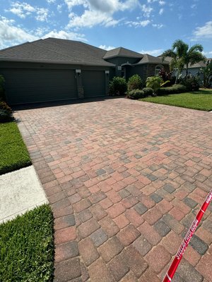 Driveway in Palm Bay. - This driveway was very dirty, with a lot of algae and mold growing on the surface and between the paver joints. We treated the entire area with the proper cleaning agents and algaecide, pressure washed with hot water to ensure everything was as clean as possible, re-sanded all the joints, and then applied two coats of a high-quality, semi-gloss, wet-look sealer. Driveway in Palm Bay. - This driveway was very dirty, with a lot of algae and mold growing on the surface and between the paver joints. We treated the entire area with the proper cleaning agents and algaecide, pressure washed with hot water to ensure everything was as clean as possible, re-sanded all the joints, and then applied two coats of a high-quality, semi-gloss, wet-look sealer.