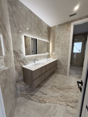 Bathroom Renovation - "¡Discover your dream bathroom! 💕 Elegant marble, modern wood vanity with double sink, LED lighting, and minimalist design. A luxurious and comfortable space that elevates your home. Contact us to remodel your bathroom like this!"