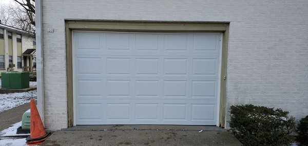 Door/Opener Replacement @ Apartment Complex Maintenance Garage - The maintenance garage at this apartment complex had an old wood door that was severely falling apart. We tore out the old door and track, replaced the door with a new steel-back insulated door and added an opener. The space was very low clearance and required a specially modified track system to allow the door to fully function. Door/Opener Replacement @ Apartment Complex Maintenance Garage - The maintenance garage at this apartment complex had an old wood door that was severely falling apart. We tore out the old door and track, replaced the door with a new steel-back insulated door and added an opener. The space was very low clearance and required a specially modified track system to allow the door to fully function.