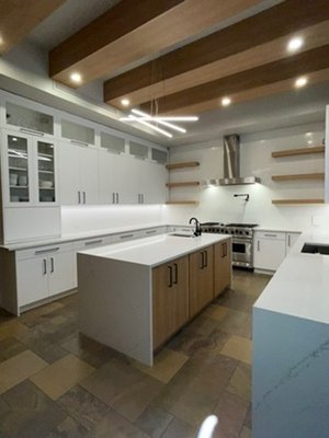 Beautiful Kitchen Remodel - This kitchen cabinet was done to brighten up the space and utilize all available wall space. The kitchen had high ceilings that needed to be utilized and an old brick fireplace that didn't belong in a modern Florida home. There were too many wood tones. We replaced the cabinets with all-white modern cabinets and stacked them with glass to utilize the high ceilings and keep an open feel. We custom-made the island in natural wood tones and custom-made matching panels for the refrigerator. Beautiful Kitchen Remodel - This kitchen cabinet was done to brighten up the space and utilize all available wall space. The kitchen had high ceilings that needed to be utilized and an old brick fireplace that didn't belong in a modern Florida home. There were too many wood tones. We replaced the cabinets with all-white modern cabinets and stacked them with glass to utilize the high ceilings and keep an open feel. We custom-made the island in natural wood tones and custom-made matching panels for the refrigerator.