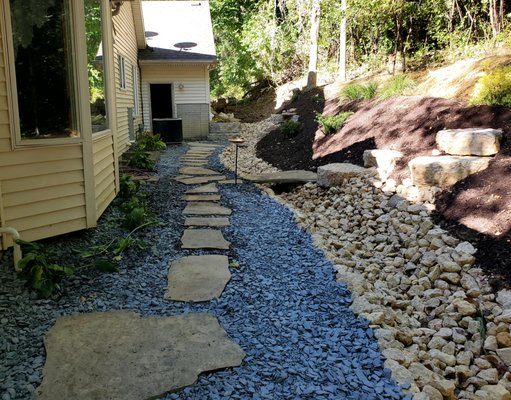 Natural Stone Landscape for Water Control - This Area had excess water run off and this will control water flow while also allowing access to plant on the hill and give a walkway to the rear of the property .
