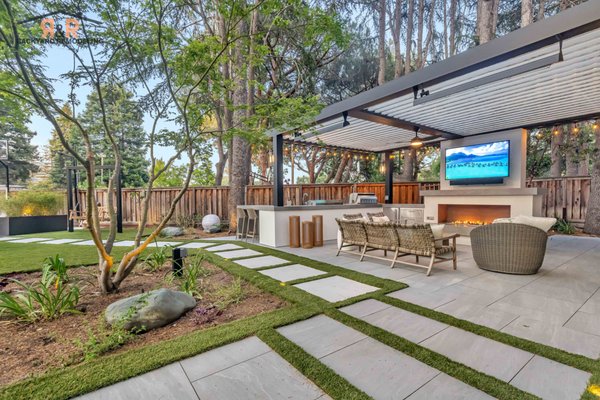 The Paulson Project | Front & Backyard Remodel - The Paulson Project in Menlo Park, CA is a fully custom outdoor retreat designed for elevated living and effortless entertaining. Every detail from the bespoke outdoor kitchen and integrated grill station to the precision-crafted pergola with ambient lighting - was tailored to the homeowners’ lifestyle. The expansive layout flows seamlessly from the lounge area with its contemporary fireplace and media wall to the open-air spaces perfect for recreation and gatherings. Premium materials, clean architectural lines, and thoughtful design unite to create a backyard that is as functional as it is sophisticated - a private haven for both relaxation and hosting at the highest level.
