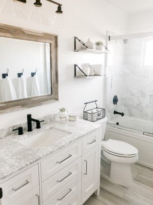 Modern Farmhouse Bathroom Remodel - This bathroom began as an outdated space with limited functionality. By reconfiguring the layout, we maximized the usable space, creating a more efficient and comfortable flow. The final design pairs clean, modern lines with farmhouse-inspired warmth, featuring marble countertops and a rustic wood mirror as key focal points. Modern Farmhouse Bathroom Remodel - This bathroom began as an outdated space with limited functionality. By reconfiguring the layout, we maximized the usable space, creating a more efficient and comfortable flow. The final design pairs clean, modern lines with farmhouse-inspired warmth, featuring marble countertops and a rustic wood mirror as key focal points.