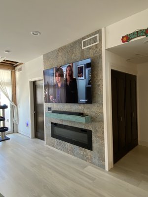 Complete TV wall custom remodel and kitchen lighting - Due to the poor design and craftsmanship on the structure in this building we had to demo the entire wall and start from scratch to ensure a level surface for our tile.
Our customer chose the colors and design of the tile and we started with demo, Cut in and support for recessed fireplace, and cable pathways for components in interior closet.
Once tile work was complete we proceeded to mount the mantle install the Soundbar cabling and finally finished with the TV . We came back a second time to finish the lighting in the kitchen and install trim on either side of the tile for a seamless look. Complete TV wall custom remodel and kitchen lighting - Due to the poor design and craftsmanship on the structure in this building we had to demo the entire wall and start from scratch to ensure a level surface for our tile.
Our customer chose the colors and design of the tile and we started with demo, Cut in and support for recessed fireplace, and cable pathways for components in interior closet.
Once tile work was complete we proceeded to mount the mantle install the Soundbar cabling and finally finished with the TV . We came back a second time to finish the lighting in the kitchen and install trim on either side of the tile for a seamless look.
