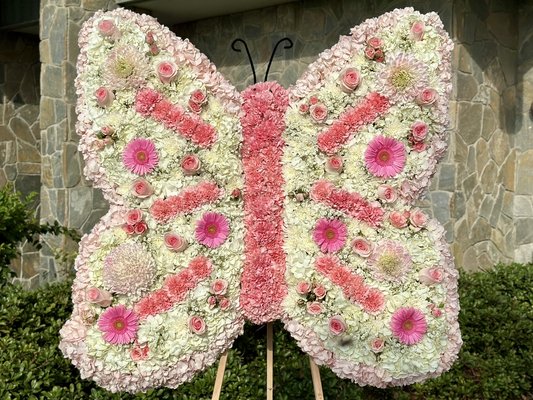 Luxury Sympathy Angel Wings Floral Tribute - A custom butterfly floral tribute designed with soft white blooms and delicate pink accents. This meaningful arrangement brings a peaceful, elegant touch to funeral and memorial services, symbolizing love, remembrance, and transformation. Each piece can be customized with preferred colors, ribbon wording, and floral details.
For custom memorial flowers, request a quote and we’ll help create something beautiful and meaningful.
