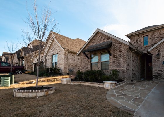 Custom Stone and Patio Cover Work - We had multiple projects at this property. We installed a new retaining wall. On either side of the house, we installed pavers and river rock. The stone borders and the flagstone walkway are new installations as well. Finally, we poured new concrete for a patio, build a custom patio cover, and a custom outdoor kitchen in the backyard.