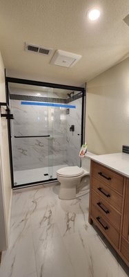 MTZ Primary bath 2026 - Original primary bath that had water damage and need updating. We removed the split wall that was breaking up the space. Gutted the bathroom down to the studs and brought everything up to code. All new fixtures , porcelain tile floor and shower tile with decorative accent. Nice large niche w/ soap shelf and Green glass tile. 60" walnut vanity w/ quartz top and matte black finishes. Slimline led sconces, circle mirror for a modern feel and led can lights. Installed a pocket door w/ soft close and soft open for privacy. MTZ Primary bath 2026 - Original primary bath that had water damage and need updating. We removed the split wall that was breaking up the space. Gutted the bathroom down to the studs and brought everything up to code. All new fixtures , porcelain tile floor and shower tile with decorative accent. Nice large niche w/ soap shelf and Green glass tile. 60" walnut vanity w/ quartz top and matte black finishes. Slimline led sconces, circle mirror for a modern feel and led can lights. Installed a pocket door w/ soft close and soft open for privacy.