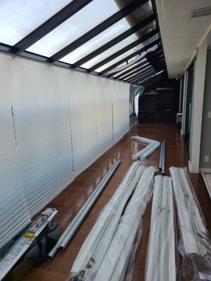 Somfy-Powered Skylight Covers For LA Home - We measured the size of the large skylights windows in the client's home in order to ensure the rolling cover provided a perfect fit, which is important especially during high sunlight hours, to prevent stray rays from creating excessive glare. Manufacturing finished quickly and we returned to install the custom skylight window covers on the large glass surface that arced from the ceiling down to the wall sections. After finishing basic functionality testing, they were good to go. Client was pleased with the work.