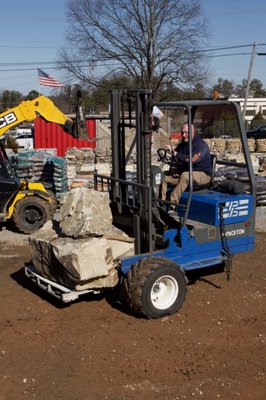 Landscape Stone and Rock Delivery in Metro Atlanta - Mountain High Landscape Supply recently completed the successful delivery of premium palletized stone for a residential hardscape project in Metro Atlanta. Utilizing our heavy-duty flatbed truck equipped with a ride-along forklift, our team ensured a seamless drop-off experience.
Unlike standard dump truck deliveries, our forklift capability allowed us to offload heavy stone pallets with precision, placing them exactly where the contractor needed them on the job site. This method minimizes risk to the driveway, eliminates manual hauling for the crew, and keeps the workspace organized. Whether you are a homeowner or a pro, we have the fleet to handle your heaviest hardscape needs. Landscape Stone and Rock Delivery in Metro Atlanta - Mountain High Landscape Supply recently completed the successful delivery of premium palletized stone for a residential hardscape project in Metro Atlanta. Utilizing our heavy-duty flatbed truck equipped with a ride-along forklift, our team ensured a seamless drop-off experience.
Unlike standard dump truck deliveries, our forklift capability allowed us to offload heavy stone pallets with precision, placing them exactly where the contractor needed them on the job site. This method minimizes risk to the driveway, eliminates manual hauling for the crew, and keeps the workspace organized. Whether you are a homeowner or a pro, we have the fleet to handle your heaviest hardscape needs.