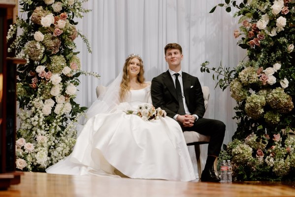 Caleb's Wedding - Caleb & Bride’s Wedding: A Timeless Celebration
At M&D Event rentals, we were honored to be a part of Caleb’s wedding, transforming their vision into a reality with our curated event rentals. This celebration exuded elegance and charm, perfectly blending classic and romantic aesthetics.
Our team provided:
- A stunning ceremony backdrop, adorned with lush florals and greenery, framing a sophisticated tufted loveseat for unforgettable moments.
- Reception tablescapes, featuring our elegant gold sunburst chargers, crystal glassware, and timeless flatware, paired with soft, neutral linens and chic wooden cross-back chairs. The design created an inviting yet refined atmosphere.
- Decor elements, including cocktail tables, dessert stations, and a sleek cake stand, ensuring every detail harmonized beautifully with the overall theme.
From the intimate cake-cutting setup to the grand dining arrangements, every element reflected Caleb and his bride’s style. We loved collaborating with their floral designer to elevate the aesthetic further.
If you’re envisioning a wedding or event that leaves a lasting impression, let us help bring your dreams to life with our exceptional rental offerings and attention to detail! Caleb's Wedding - Caleb & Bride’s Wedding: A Timeless Celebration
At M&D Event rentals, we were honored to be a part of Caleb’s wedding, transforming their vision into a reality with our curated event rentals. This celebration exuded elegance and charm, perfectly blending classic and romantic aesthetics.
Our team provided:
- A stunning ceremony backdrop, adorned with lush florals and greenery, framing a sophisticated tufted loveseat for unforgettable moments.
- Reception tablescapes, featuring our elegant gold sunburst chargers, crystal glassware, and timeless flatware, paired with soft, neutral linens and chic wooden cross-back chairs. The design created an inviting yet refined atmosphere.
- Decor elements, including cocktail tables, dessert stations, and a sleek cake stand, ensuring every detail harmonized beautifully with the overall theme.
From the intimate cake-cutting setup to the grand dining arrangements, every element reflected Caleb and his bride’s style. We loved collaborating with their floral designer to elevate the aesthetic further.
If you’re envisioning a wedding or event that leaves a lasting impression, let us help bring your dreams to life with our exceptional rental offerings and attention to detail!