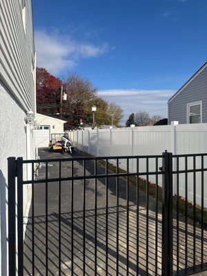 6' High White Vinyl and 54" High Ornamental Aluminum Double Drive Gate - Completed the installation of an 8' wide x 54" high three-rail ornamental aluminum double gate, paired with a 6' high white vinyl privacy fence for enhanced security and privacy.