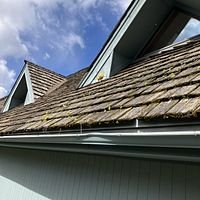 Cedar Shake to Asphalt Shingles - This reroof project involved replacing an old, moss-covered cedar shake roof with durable, modern IKO Armor Shake asphalt shingles. The original cedar shakes showed significant wear, weathering, and moss buildup, which compromised the roof’s protection and aged the home’s appearance. Our team carefully removed the aging shakes during the tear-off phase, inspected and prepped the decking, and then installed high-quality IKO Armor Shake shingles. These shingles offer the rustic look of wood shakes but with enhanced durability, weather resistance, and low maintenance—providing the home with a fresh, stylish, and long-lasting roof that blends classic charm with modern performance.