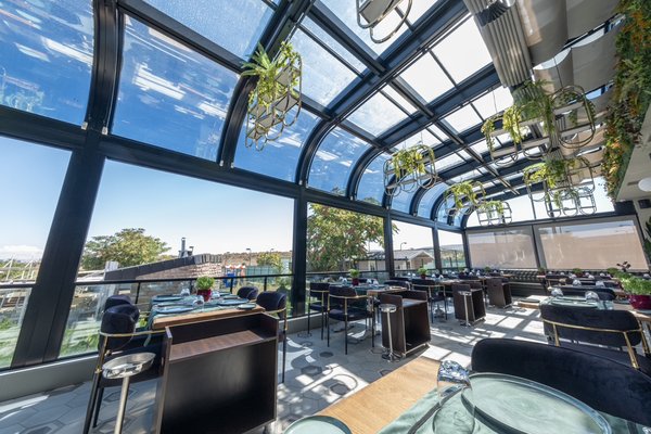 Curved Retractable Sunroom Project - Experience sheer luxury with Luxurio's state-of-the-art Curved Sunroom at a tennis country club. This project was not an easy task but after the completion it was well worth it. The owner is thrilled with this new upgraded space for his members to enjoy. It fits perfectly in the space protecting a restaurant from the outdoor elements and exhibiting modern architectural beauty. Not only has it added value to his established club but he has created a haven of comfort and luxury to his members. Curved Retractable Sunroom Project - Experience sheer luxury with Luxurio's state-of-the-art Curved Sunroom at a tennis country club. This project was not an easy task but after the completion it was well worth it. The owner is thrilled with this new upgraded space for his members to enjoy. It fits perfectly in the space protecting a restaurant from the outdoor elements and exhibiting modern architectural beauty. Not only has it added value to his established club but he has created a haven of comfort and luxury to his members.
