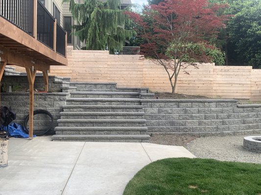 Allan Block Steps and Horizontal Fence - We constructed this stairway entrance to our customers back yard using Allan Block and 2x2 plaza pavers for the landing area. We also created a system of retaining walls to allow for a level back yard, we installed underground irrigation throughout. During the project the customer had us install a horizontal fence around his property also. We did not do the grass or any of the final landscaping he chose to do that on his own.