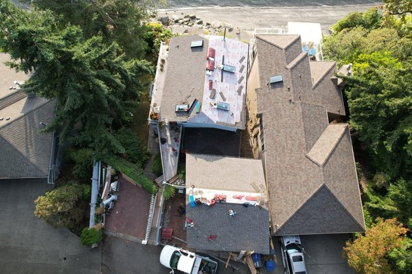 Waterfront home in Seatac 4 story tall house roof replacement with garage - We tore off the old asphalt shingle roof on the house and the garage and put a brand new asphalt shingle roof. We also replaced all the skylights also. Waterfront home in Seatac 4 story tall house roof replacement with garage - We tore off the old asphalt shingle roof on the house and the garage and put a brand new asphalt shingle roof. We also replaced all the skylights also.