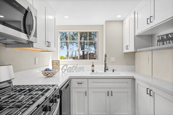 Chappellet Project - Bright modern kitchen with white Shaker cabinets, quartz countertops, and a functional U-shaped layout.  inviting space perfect for everyday living.