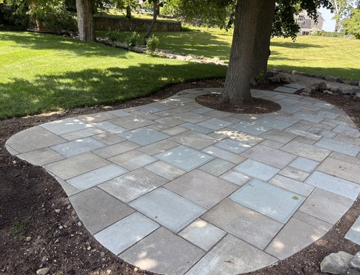Bluestone patio Marblehead MA - Customer wanted a patio built into the existing landscape that would blend in with the surroundings .