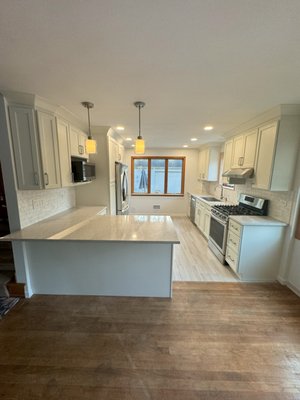 Glenview Kitchen Remodel - This Glenview family wanted to upgrade their tight and dark kitchen to a fresh and bright new space. Regency helped our client's achieve their goal. The biggest transformation was removing the wall between the kitchen and living area, creating a large peninsula that expanded the work space and opened the kitchen up. Regency's dove white cabinets offer the brightness our clients were after, and the Calacatta Odyssey countertops from Daltile were the perfect pick. Our clients chose top of the line appliances from ABT to complete their new space. Glenview Kitchen Remodel - This Glenview family wanted to upgrade their tight and dark kitchen to a fresh and bright new space. Regency helped our client's achieve their goal. The biggest transformation was removing the wall between the kitchen and living area, creating a large peninsula that expanded the work space and opened the kitchen up. Regency's dove white cabinets offer the brightness our clients were after, and the Calacatta Odyssey countertops from Daltile were the perfect pick. Our clients chose top of the line appliances from ABT to complete their new space.