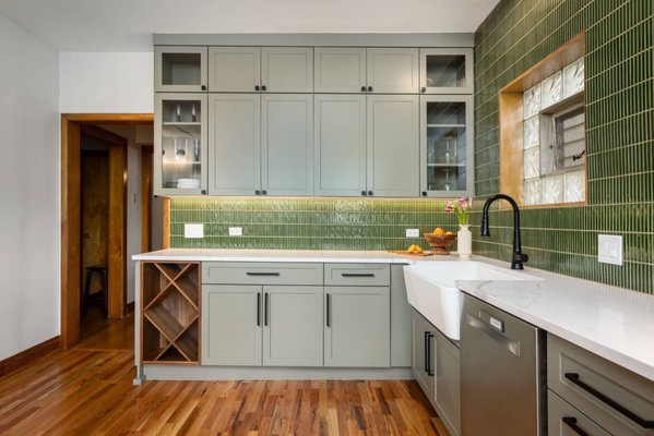 Winnemac Kitchen Remodel: Serene Green Interior - This kitchen remodel embraces a calming palette of soft olive to deep green tones, accented by black fixtures for a modern edge. Clean lines and warm wood finishes create a space that feels both refined and effortlessly inviting.
Designed with serene, nature-inspired tones, featuring soft sage-green cabinetry and a textured green tile backsplash that adds depth and character. The L-shaped layout maximizes storage and workflow, while under-cabinet lighting, stainless steel appliances, and a statement range hood bring a modern touch. Warm wood flooring and a cozy window-side seating area complete the space, creating a functional kitchen that feels bright, inviting, and connected to everyday living.
Project designed by Chi Renovation, a renowned renovation firm based in Skokie. We specialize in general contracting, kitchen and bath remodeling, and design & build services. We cater to the entire Chicago area and its surrounding suburbs, with emphasis on the North Side and North Shore regions. You'll find our work from the Loop through Lincoln Park, Skokie, Evanston, Wilmette, and all the way up to Lake Forest. Winnemac Kitchen Remodel: Serene Green Interior - This kitchen remodel embraces a calming palette of soft olive to deep green tones, accented by black fixtures for a modern edge. Clean lines and warm wood finishes create a space that feels both refined and effortlessly inviting.
Designed with serene, nature-inspired tones, featuring soft sage-green cabinetry and a textured green tile backsplash that adds depth and character. The L-shaped layout maximizes storage and workflow, while under-cabinet lighting, stainless steel appliances, and a statement range hood bring a modern touch. Warm wood flooring and a cozy window-side seating area complete the space, creating a functional kitchen that feels bright, inviting, and connected to everyday living.
Project designed by Chi Renovation, a renowned renovation firm based in Skokie. We specialize in general contracting, kitchen and bath remodeling, and design & build services. We cater to the entire Chicago area and its surrounding suburbs, with emphasis on the North Side and North Shore regions. You'll find our work from the Loop through Lincoln Park, Skokie, Evanston, Wilmette, and all the way up to Lake Forest.