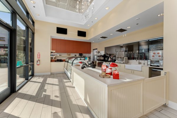 Southern Girl Desserts - Watts - After over ten successful years of business, Southern Girl Desserts, winners of Food Network’s Cupcake Wars, was quickly outgrowing their first space. Employees were bumping into each other, and equipment had to be creatively stored, including in a moving shed in the parking lot. 

The design of this second location ties in their unique southern branding elements, but the primary objective was to provide more space. A larger commercial kitchen increased their output capacity and allowed for new equipment to add new offerings.  

Multiple work surfaces, ample lighting, and 10-foot ceilings made a huge difference in productivity and comfort for the team. The expansive glass between the kitchen and sales area showcases the amazing chefs at work and creates a visual connection to the community they served.