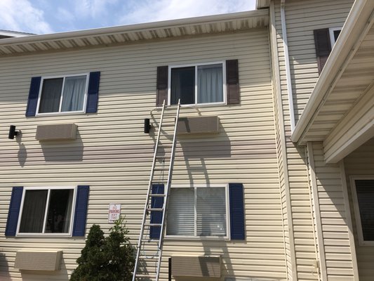 Days Inn Hotel Shutters - We sprayed the shutters a vibrant blue to give them a refreshed and eye-catching look. To ensure a clean and efficient process, we took down each shutter individually and carefully laid down a plastic cover inside the hotel for the spraying process. Additionally, we extended our expertise to the concrete footing surrounding the hotel and repainted them a bright white.