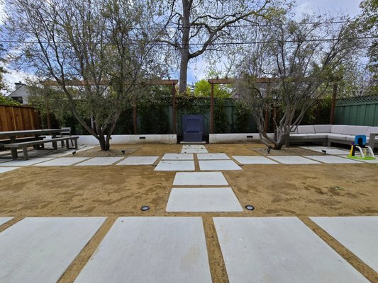 The Art of Stepping Concrete - Are you looking to create a yard that’s not only beautiful but also easy to maintain? 
Our recent project features stepping concrete stones that deliver a modern and elegant aesthetic. With clean lines and a minimalist design, this style transforms any outdoor space into a sleek, sophisticated retreat. Stepping concrete stones add texture and structure without overwhelming the natural beauty of the yard, making it perfect for those who love a simple yet grand look. Plus, it’s a breeze to keep clean and maintain! 
Whether you want a peaceful place to relax or an inviting space to entertain, this design brings together functionality and style, creating a yard that stands out all year long.