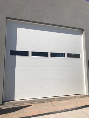 RV Garage Doors and High Lift - This project consisted of 2 RV garage doors and one full view all glass door. The two smaller doors were installed with high lift track systems so that when opened they go all the way up to the ceiling and match the open height of the largest door in the front of this garage. A wall mount jack shaft opener was used on the tall door to save space, this same type of opener could also be used on the high lift doors as well. This saves quite a bit of headroom so that a car lift, mezzanine or large vehicle can be placed in any where in the garage.
This project was completed in a day and a half and our client was very happy with the result. We take tremendous pride in our work and in meeting the challenges of our customers specialty projects and requirements. RV Garage Doors and High Lift - This project consisted of 2 RV garage doors and one full view all glass door. The two smaller doors were installed with high lift track systems so that when opened they go all the way up to the ceiling and match the open height of the largest door in the front of this garage. A wall mount jack shaft opener was used on the tall door to save space, this same type of opener could also be used on the high lift doors as well. This saves quite a bit of headroom so that a car lift, mezzanine or large vehicle can be placed in any where in the garage.
This project was completed in a day and a half and our client was very happy with the result. We take tremendous pride in our work and in meeting the challenges of our customers specialty projects and requirements.