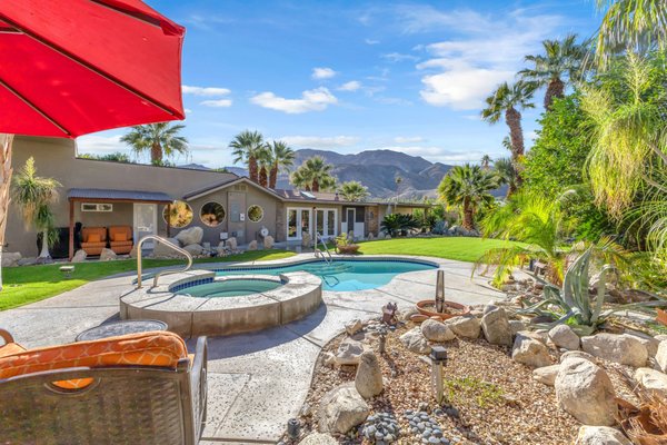 NEW LISTING!! Stunning Estate with Park-like Grounds - Welcome to 70142 Mirage Cove, a private and gated Rancho Mirage estate set on more than an acre of beautifully curated, park like grounds. Enclosed by a tall wall of mature Ficus and framed by dramatic desert mountain views, the property carries a peaceful, almost hidden quality that sets it apart from anything else. The main residence blends mid-century character with thoughtful modern updates. Iconic round windows, high beamed ceilings, and light plank floors create an inviting and refined foundation, while natural light highlights distinctive architectural touches. True dual primaries elevate daily living, while refreshed lighting, paint, kitchen finishes, and tankless water heaters provide thoughtful modern updates. With four bedrooms and three bathrooms, plus an attached enclosed two-car garage, the main home offers comfort, flexibility, and architectural charm in equal measure. At the far edge of the property, the detached guest house is its own private retreat. Set behind another electric gate and featuring a full kitchen, separate bedroom, bathroom, laundry, and patio, this ADU is ideal for multi-generational living, extended guests, a caregiver, or fully independent quarters. The separation from the main home creates a sense of privacy that is rare and incredibly valuable. For hobbyists, creatives, or RV owners, the newly constructed oversized RV and two-car garage is a standout feature. Full RV hookups and generous workspace make it well suited for automotive enthusiasts, woodworking, storage, or large-scale projects that require room to imagine and build. The property also includes leased solar for added efficiency. The grounds have recently been enhanced with new irrigation and professional landscaping, creating an environment that feels both intentional and delightfully unexpected. Mature trees, open lawns, shaded sitting areas, and a charming tree house contribute to a sense of whimsy that makes the property feel truly magical. Every corner offers a quiet moment or a thoughtful detail waiting to be discovered. This is an exceptional opportunity to own a private Rancho Mirage compound in a setting that feels like a hidden desert retreat. Come experience the serenity and beauty of this sanctuary today.