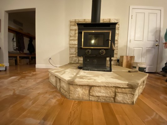 Free Standing Fire Place Installation - This client wanted us to install a free standing fire place in their house to help save money so they wouldn't have top use their propane heater. The client chose this spot to place the fire place. We did everything from installing the rock, to building the platform,and installing the flu.