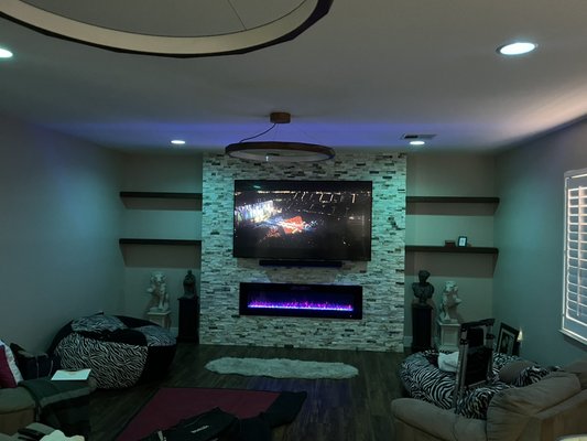 My Game room Remodel - My game room is about 550 sq ft and the carpet, paint and fixtures were just out right outdated. The floors had stains as you can see from the photos, from the animal and kids (also animals), the walls were in need of paint and the baseboards replaced. I removed all the old materials, painted the floor with kills after making sure it was all level and filled any holes. Then did the luxury wood vinyl but first did an underlayment for noise reduction and energy efficiency. Then framed in a fireplace/TV wall, added electrical and low voltage abilities, then did stone work, then added a fireplace and TV. Finally painted the room and new baseboards, and added new modern wood light fixtures and a few new outlets. My Game room Remodel - My game room is about 550 sq ft and the carpet, paint and fixtures were just out right outdated. The floors had stains as you can see from the photos, from the animal and kids (also animals), the walls were in need of paint and the baseboards replaced. I removed all the old materials, painted the floor with kills after making sure it was all level and filled any holes. Then did the luxury wood vinyl but first did an underlayment for noise reduction and energy efficiency. Then framed in a fireplace/TV wall, added electrical and low voltage abilities, then did stone work, then added a fireplace and TV. Finally painted the room and new baseboards, and added new modern wood light fixtures and a few new outlets.