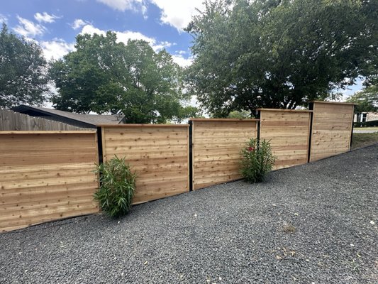 Custom 6'H Horizontal Cedar with 3" Square Black Steel Posts, Top Cap, and Post Trim + Welded Steel Gate - This homeowner wanted a barrier between her front yard and the neighbor's in order to provide some privacy. The yard was on a bit of a slope, so we used a stepped fence height approach. We used 3" square black steel posts and Western Red Cedar lumber. In order to match the premium look of the black steel posts, we custom-welded a 4-foot-wide walk gate with a custom door pull and lockable latch. Custom 6'H Horizontal Cedar with 3" Square Black Steel Posts, Top Cap, and Post Trim + Welded Steel Gate - This homeowner wanted a barrier between her front yard and the neighbor's in order to provide some privacy. The yard was on a bit of a slope, so we used a stepped fence height approach. We used 3" square black steel posts and Western Red Cedar lumber. In order to match the premium look of the black steel posts, we custom-welded a 4-foot-wide walk gate with a custom door pull and lockable latch.