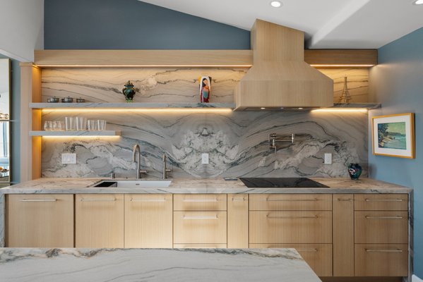 Del Mar Full House Remodel - Creative Design & Build proudly completed this elegant full-home remodel in the heart of Del Mar, California. This transformation showcases our commitment to modern luxury, attention to detail, and functional beauty.
Kitchen
The kitchen features a breathtaking natural stone slab backsplash and countertop with dramatic bookmatched veining that creates a striking focal point. The soft wood-tone cabinetry adds warmth and sophistication, complemented by minimalist hardware and integrated lighting. Floating shelves with underlighting enhance functionality and showcase curated décor, while a custom range hood and dual faucet sink station blend modern convenience with clean design.
Bathroom One
This serene bathroom remodel includes a wall-mounted vanity with sleek linear handles and a dual-faucet sink. The geometric blue-and-white tile creates a refreshing accent, complemented by warm textured wall finishes. Frameless glass doors and polished fixtures complete the refined, spa-like atmosphere.
Bathroom Two
The second bathroom reveals a bold design with contrasting materials. A unique blend of ribbed wood paneling and glossy green geometric tile defines the walk-in shower, accented by a floating quartz bench and a natural pebble shower floor. Modern brushed nickel fixtures and a frameless glass enclosure elevate the space into a true statement of style and comfort. Del Mar Full House Remodel - Creative Design & Build proudly completed this elegant full-home remodel in the heart of Del Mar, California. This transformation showcases our commitment to modern luxury, attention to detail, and functional beauty.
Kitchen
The kitchen features a breathtaking natural stone slab backsplash and countertop with dramatic bookmatched veining that creates a striking focal point. The soft wood-tone cabinetry adds warmth and sophistication, complemented by minimalist hardware and integrated lighting. Floating shelves with underlighting enhance functionality and showcase curated décor, while a custom range hood and dual faucet sink station blend modern convenience with clean design.
Bathroom One
This serene bathroom remodel includes a wall-mounted vanity with sleek linear handles and a dual-faucet sink. The geometric blue-and-white tile creates a refreshing accent, complemented by warm textured wall finishes. Frameless glass doors and polished fixtures complete the refined, spa-like atmosphere.
Bathroom Two
The second bathroom reveals a bold design with contrasting materials. A unique blend of ribbed wood paneling and glossy green geometric tile defines the walk-in shower, accented by a floating quartz bench and a natural pebble shower floor. Modern brushed nickel fixtures and a frameless glass enclosure elevate the space into a true statement of style and comfort.